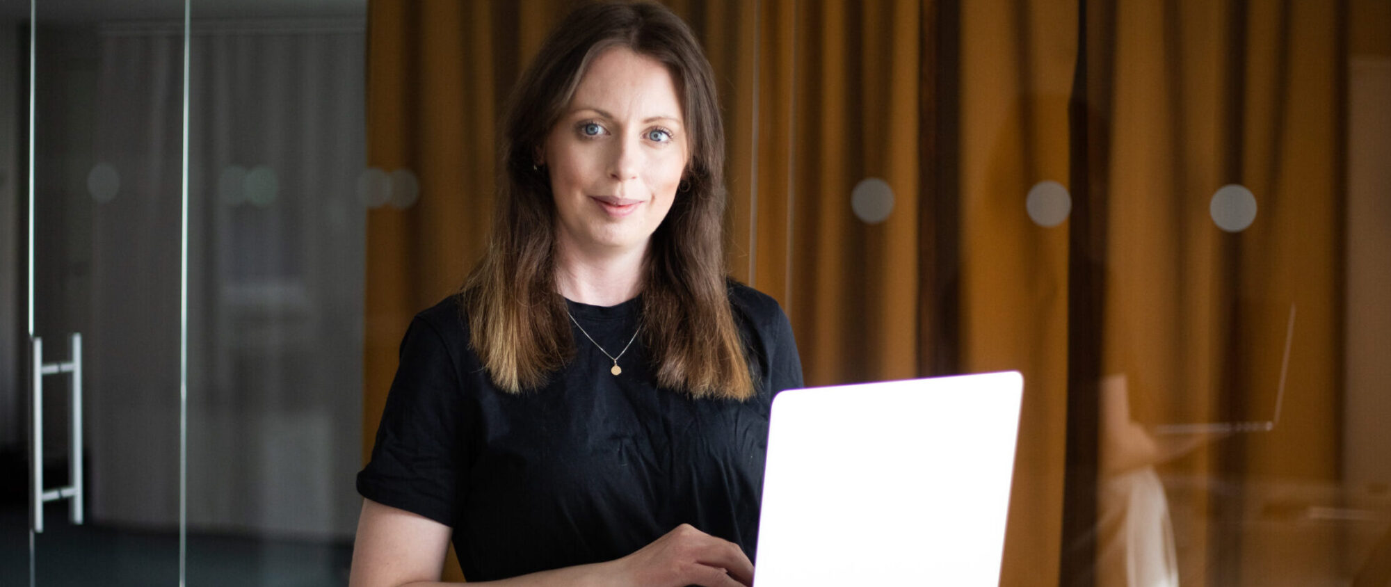 Linnea står med dator